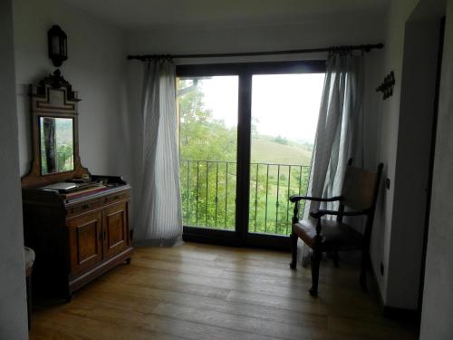 a room with a window and a chair and a mirror at Ciabòt Taricchi in Dogliani