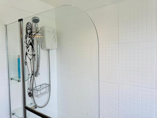 a shower in a white tiled wall with a showerigunigun at Luxe 2 Bedroom House Derby City in Derby