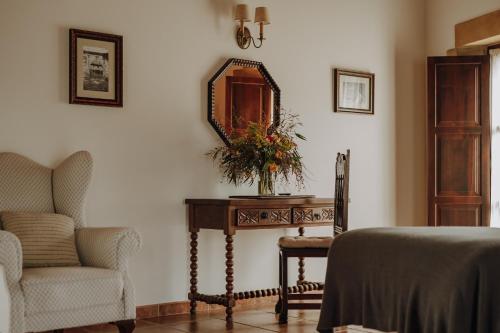 a bedroom with a table with a mirror and a chair at Hotel Palacio de Caranceja in Reocín