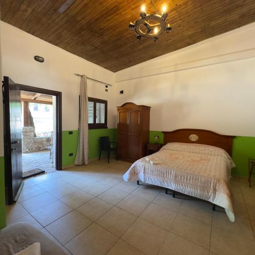 a bedroom with a bed with green walls and a ceiling at Le Chiancate in San Giovanni Rotondo