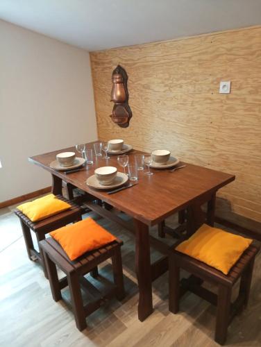 - une table en bois avec des chaises, des assiettes et des verres dans l'établissement Chalet des Prés de la Fontaine, 