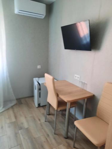 a room with a table and a tv on the wall at Solmaris in Odesa
