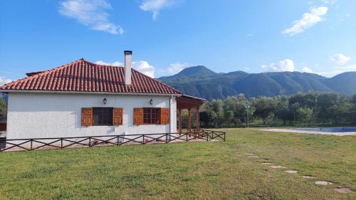 a small white house with a red roof on a field at Johnny Jo Villa in Aígio