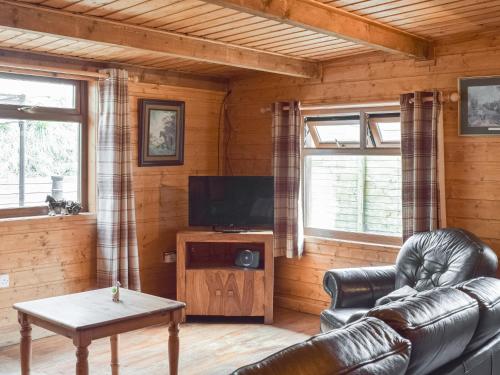 a living room with leather furniture and a flat screen tv at Cow Boy Cabin - Uk47145 in Glasgow