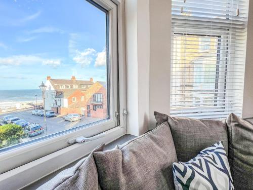 a couch in front of a window with a view of the ocean at Salty Towers in Saltburn-by-the-Sea