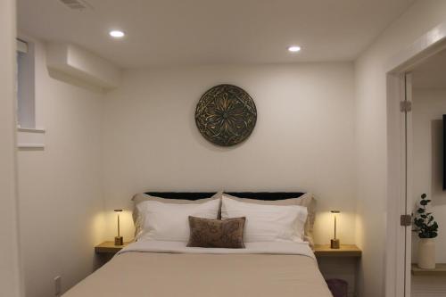 a bedroom with a bed with a clock on the wall at Queen Bed Suite-Private Entrance in Barrie