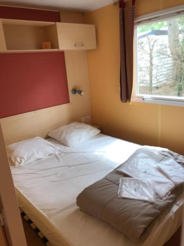une chambre avec deux lits et une fenêtre dans l'établissement MOBIL HOME proche de la mer, à Grand-Village-Plage