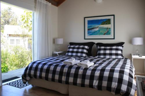 a bedroom with a bed, a desk, and a painting on the wall at Mangawhai Chalets in Mangawhai