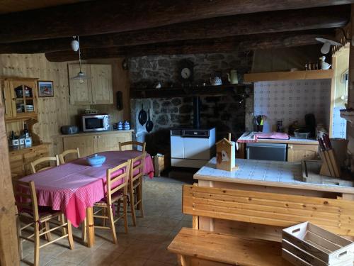 une cuisine avec une table et des chaises dans une pièce dans l'établissement Chez Marie, à Allanche