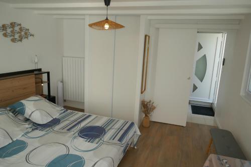 a bedroom with a bed with a blue and white comforter at Gîte 2 pers en studio indépendant chez l'habitant pour nuitée au calme et proche de la plage in Saint-Georges-de-Didonne