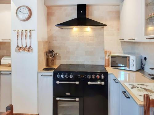 a kitchen with a black stove top oven at Borough Beck Cottage in Helmsley