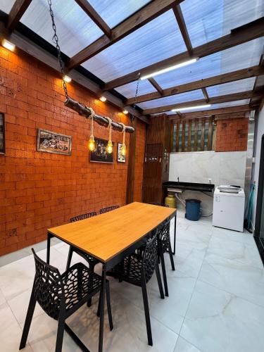 een eetkamer met een houten tafel en stoelen bij Casa Nova - Moderna | 700m praia | 8 min parque in São Lídio