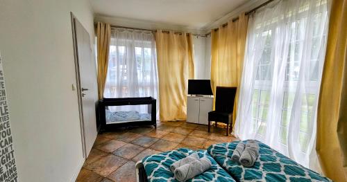 a bedroom with a bed and a desk and windows at Ferienwohnung Fink in Gallin