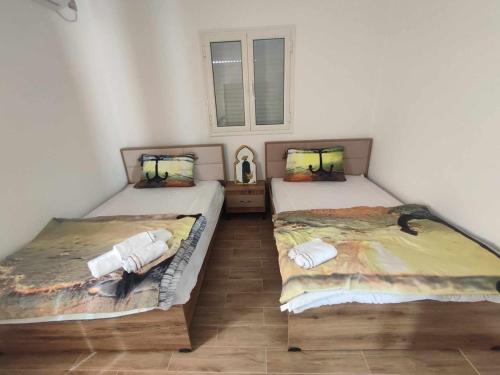 two twin beds in a room with aermottermottermott at Ashyana - Charming Villa in a quiet & peaceful area in Mezraya