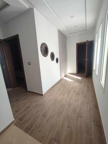 an empty room with white walls and wooden floors at Ashyana - Charming Villa in a quiet & peaceful area in Mezraya