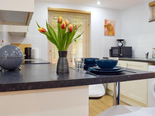 a kitchen with a counter with a vase of flowers at The Studio in Long Hanborough
