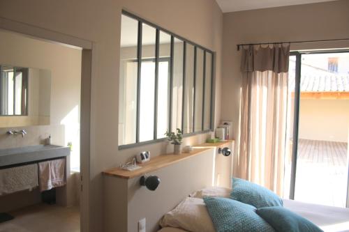 a bedroom with a bed and a sink and a mirror at La Magnanerie de l'Isle B&B in LʼIsle-sur-la-Sorgue