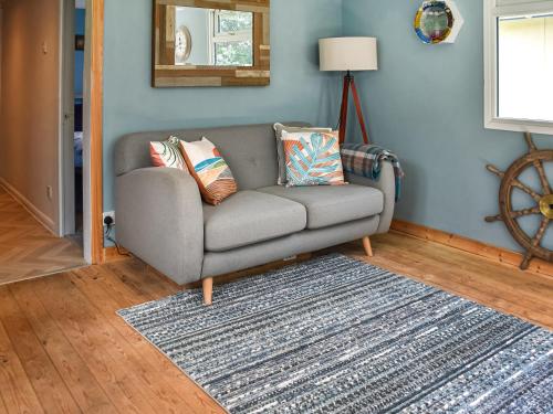 a living room with a gray couch and a rug at Seaglass Chalet - Uk47636 in Mundesley