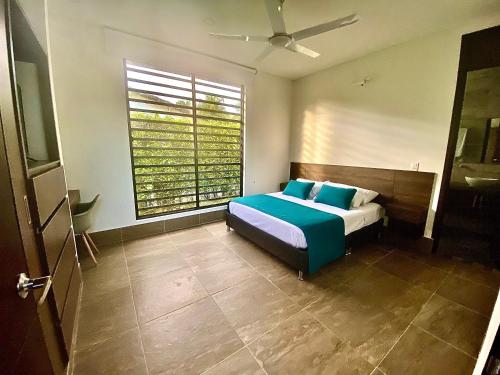 a bedroom with a bed and a large window at Casa Campestre Ocarros in Villavicencio