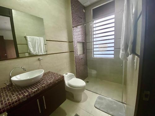 a bathroom with a sink and a toilet and a shower at Casa Campestre Ocarros in Villavicencio