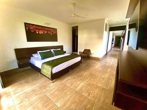 a bedroom with a large bed with green pillows at Casa Campestre Ocarros in Villavicencio