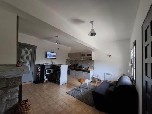 un salon avec un canapé et une cuisine dans l'établissement F2 Les Figuiers proche Ajaccio, à Sarrola-Carcopino