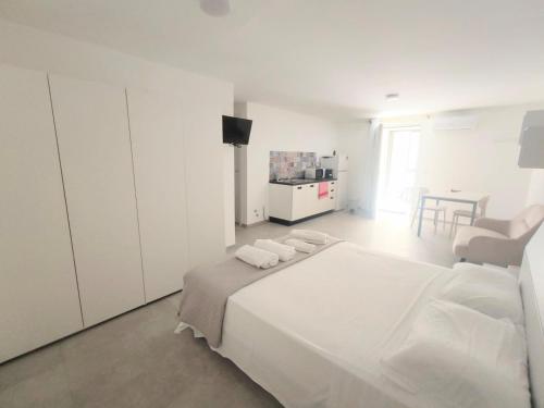 a white bedroom with a large bed and a table at Noah&Chris Apartments in Bitritto