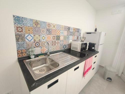 a kitchen with a sink and a refrigerator at Noah&Chris Apartments in Bitritto