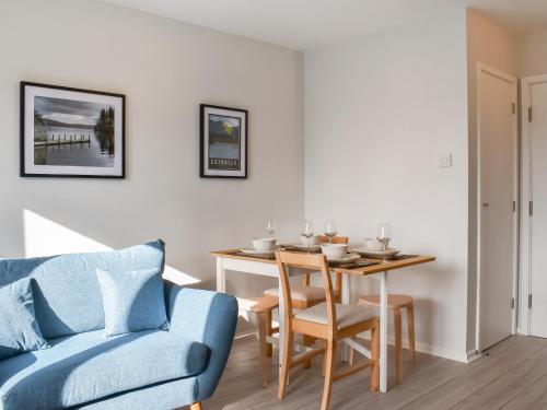 a living room with a table and a blue couch at Hillside At Bowness in Windermere