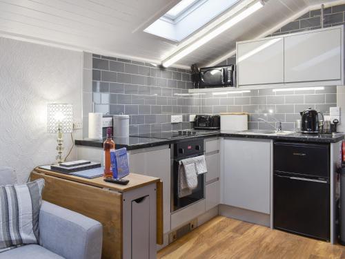 a kitchen with stainless steel appliances and a table at Cuillin View Apartment - Uk12529 in Arisaig