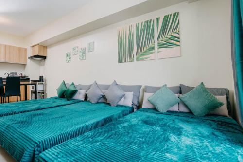 two beds in a room with blue pillows at NEW Elegant 1BR Condo Cebu IT Park Hotspot in Cebu City