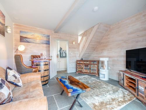 ein Wohnzimmer mit Couch und Fernseher in der Unterkunft The Drunken Carpenter's Cottage in Sneaton
