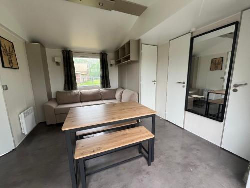 un salon avec une table et un canapé dans l'établissement bungalow de l'escaut, 