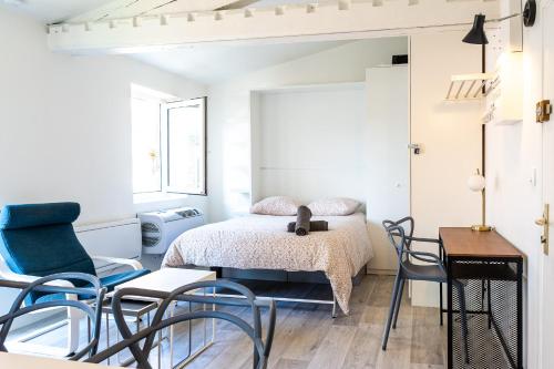 - une chambre avec un lit, des chaises et une table dans l'établissement Le Petit Jardin - Charmant studio pour 2 personnes centre historique, à Clermont-Ferrand