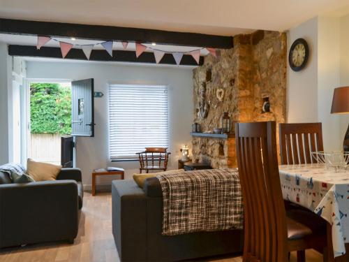 a living room with a bed and a dining room at Horseshoe Cottage in Porchfield