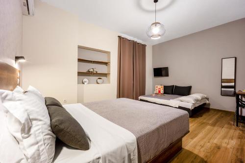 a bedroom with two beds and a living room at Aethon Airport Project-FREE SHUTTLE by GK Properties in Markopoulo