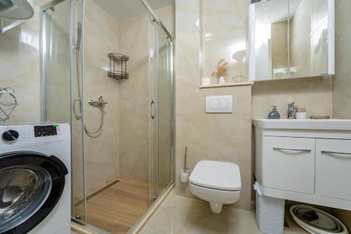 bagno con doccia, servizi igienici e lavatrice. di Alpha Mare a Bar