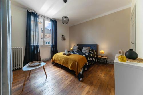 une chambre avec un lit, une table et une fenêtre dans l'établissement Le Desbrest - Appartement calme et lumineux en centre ville, à Vichy