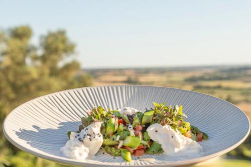 a salad on a blue plate with whipped cream at Reserva Rotana Golf Resort in Manacor