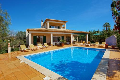 a villa with a swimming pool in front of a house at Casa Alha in Carvoeiro