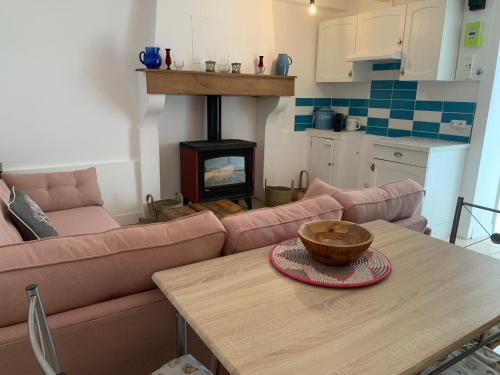 un salon avec un canapé et une table avec un poêle à bois dans l'établissement Cosy French retreat in Brettes, à Brettes