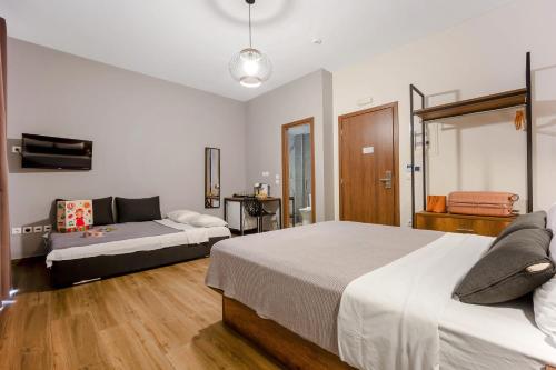 a bedroom with two beds and a couch in it at Aethon Airport Project-FREE SHUTTLE by GK Properties in Markopoulo