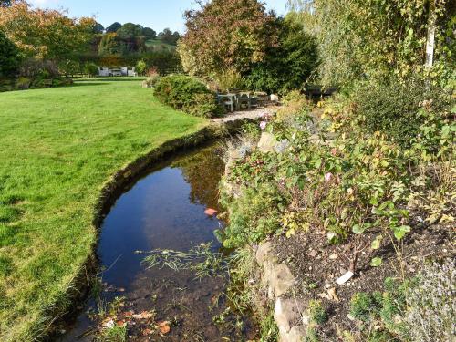 a bridge over a river in a grass field at Winebeck Farm Studio in Addingham