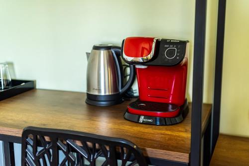 a coffeemaker sitting on top of a wooden table at Aethon Airport Project-FREE SHUTTLE by GK Properties in Markopoulo
