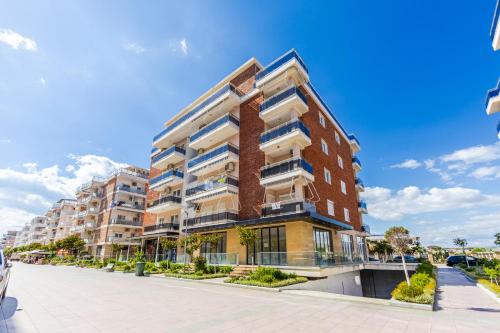 an apartment building with balconies on a street at Olivia's Apartments in Velipojë
