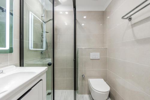 a bathroom with a shower and a toilet and a sink at Olivia's Apartments in Velipojë