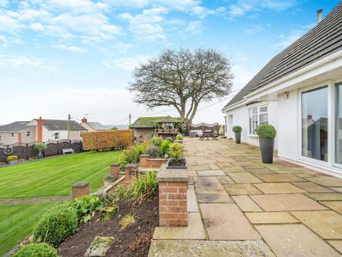 a garden with a patio and a lawn at Delcroft in Drybrook