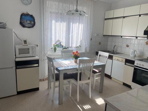 a kitchen with a table and chairs and a microwave at Hiša Tavčar in Dutovlje
