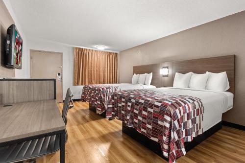 a hotel room with two beds and a table at Red Roof Inn Memphis - Graceland Airport in Memphis