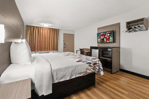 a hotel room with a large bed and a desk at Red Roof Inn Memphis - Graceland Airport in Memphis